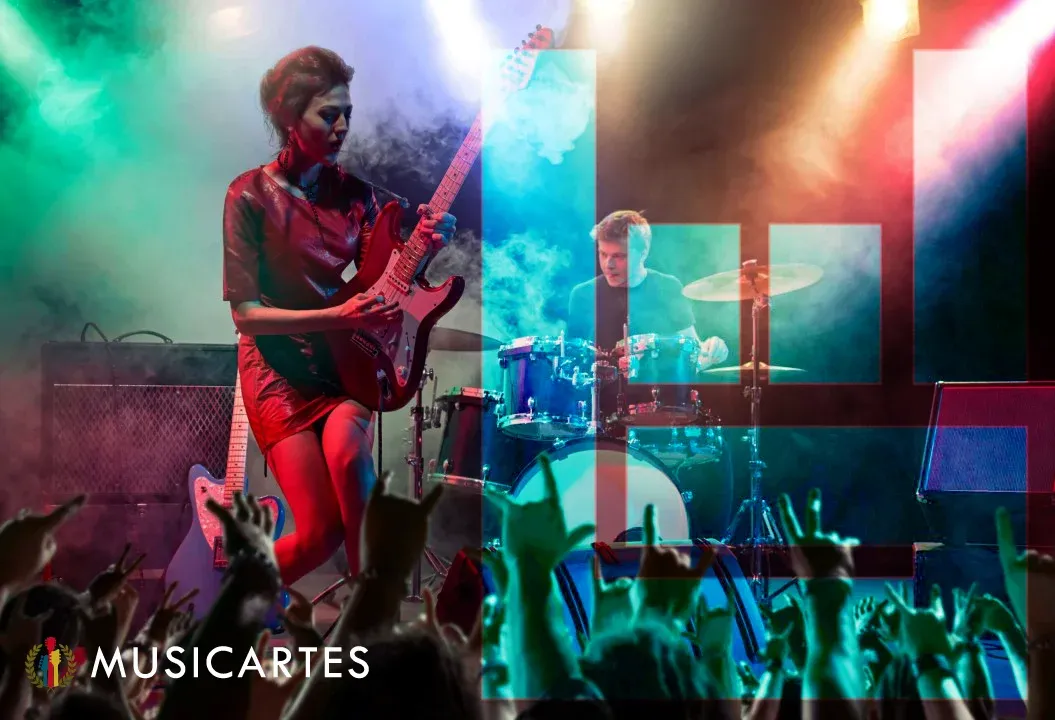 Guitarrista y baterista tocando en un escenario con luces de colores frente al público.