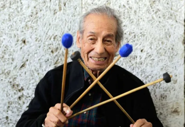 El maestro Robelio Méndez sonríe con baquetas de marimba en las manos.